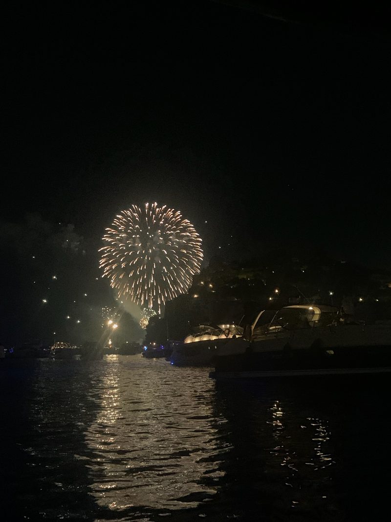 Fuochi d'artificio sulla costa visti dalla barca di sera