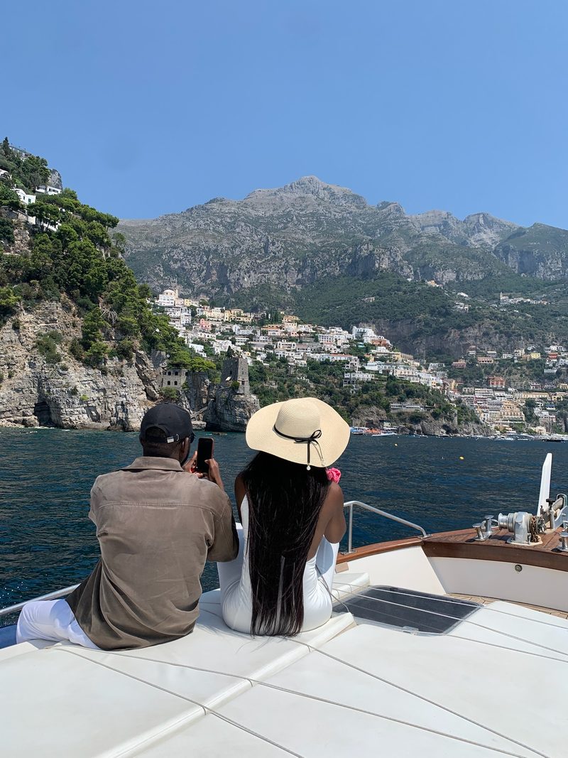 Una coppia a prua guarda Positano arroccata sulla costa