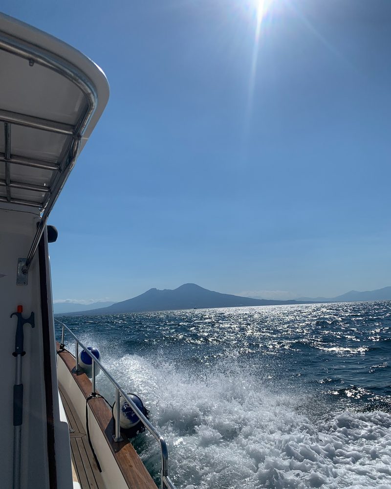 La scia della barca in uscita dal golfo, con il Vesuvio sullo sfondo