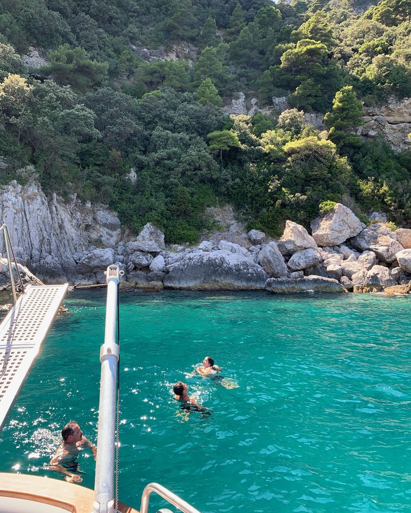 Ospiti in acqua smeraldo davanti alla costa di Capri, con la passerella calata
