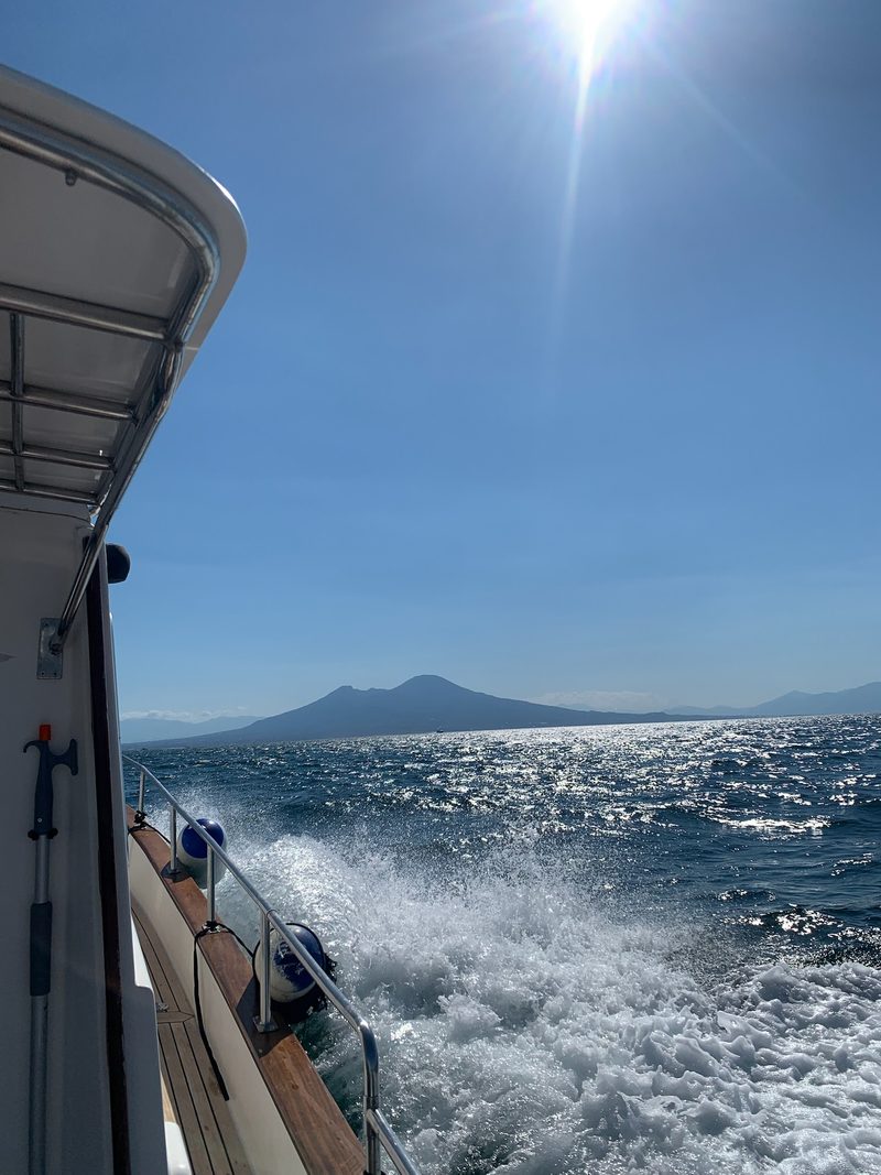 La scia della barca con il Vesuvio all'orizzonte