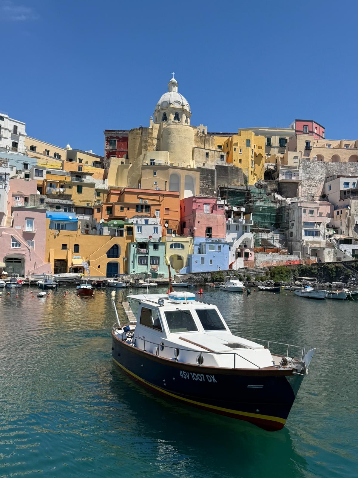 Bow three-quarter view of the classic Italian boat in Procida harbour, mahogany trim and teak details